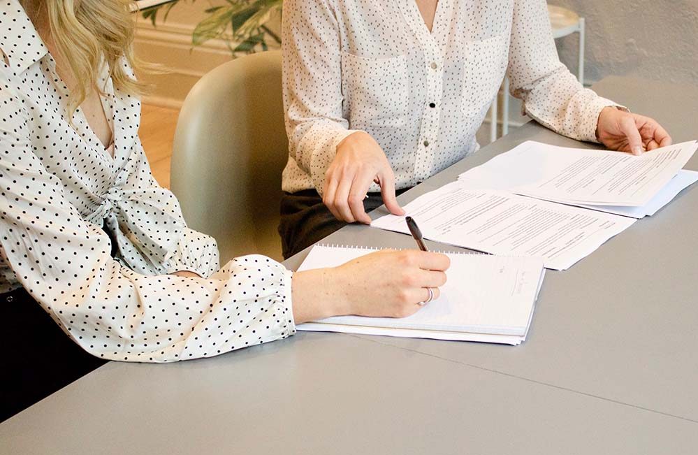 two women filling out legal documents