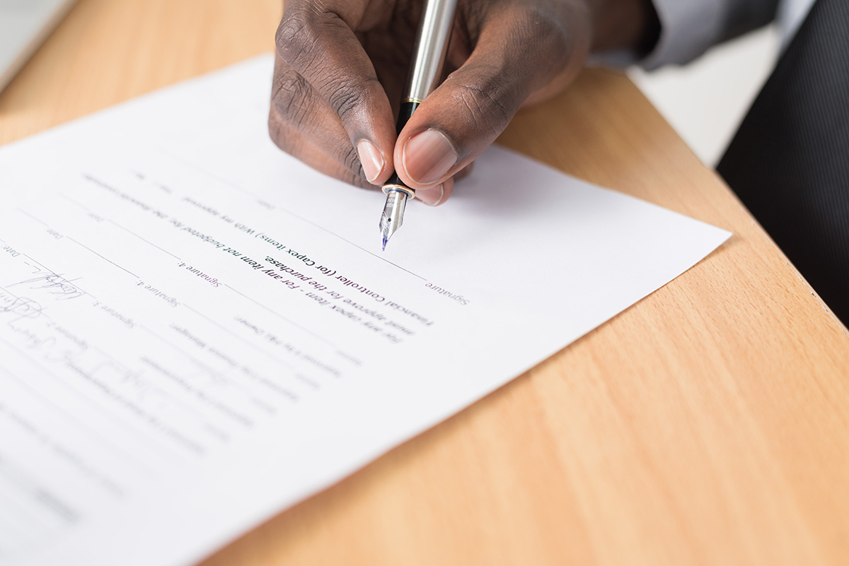 man writing on legal document